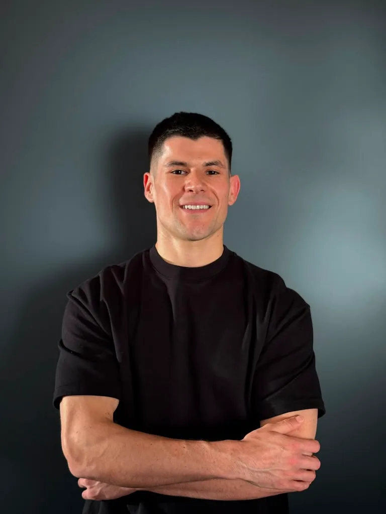 Ruben, founder of TastyFitChef, smiling with arms crossed in the kitchen