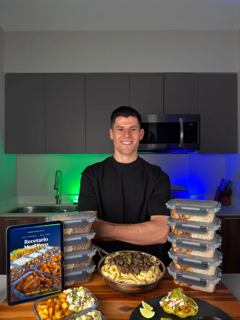 Chef detrás de una sartén con envases de vidrio apilados y el recetario en un iPad