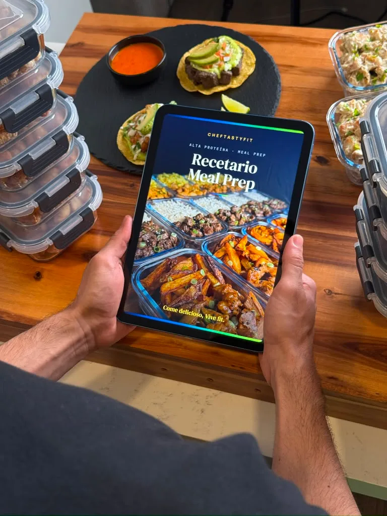 Manos sosteniendo un iPad con el recetario, cocina al fondo